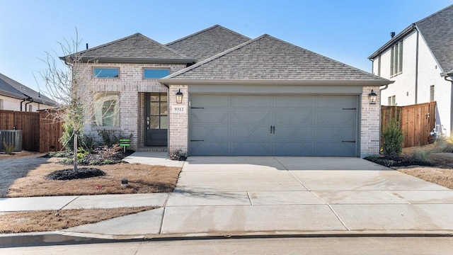 view of front of property with driveway, fence, brick siding, and roof with shingles