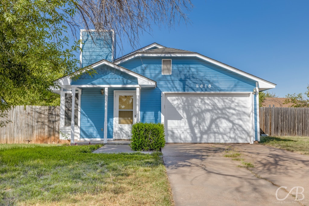 view of front of property with a garage and a front lawn