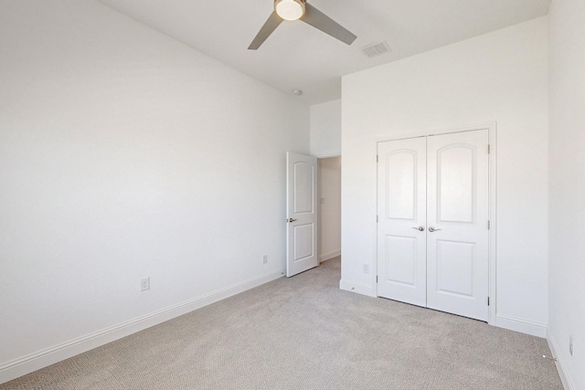 unfurnished bedroom with light colored carpet, a closet, and ceiling fan