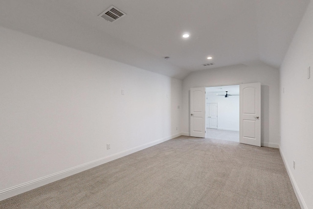 empty room featuring light carpet and vaulted ceiling