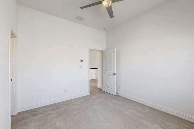 carpeted spare room featuring ceiling fan