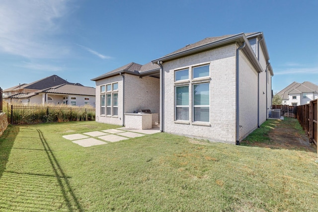 back of property with a yard, central AC, and a patio area