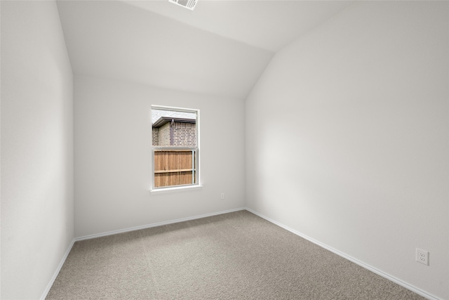 empty room with lofted ceiling and carpet flooring