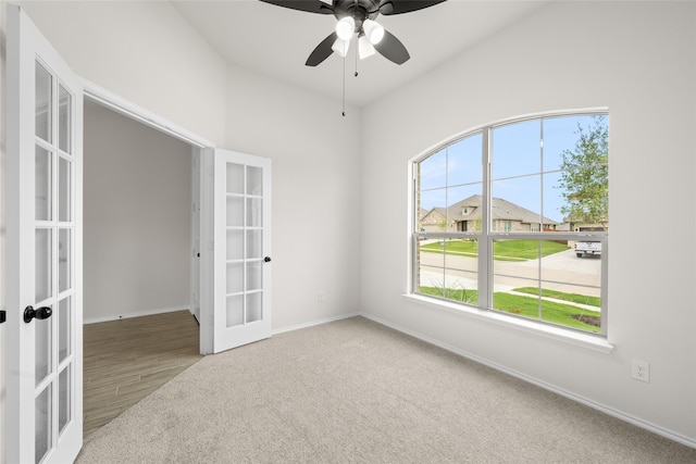 carpeted empty room with french doors and ceiling fan