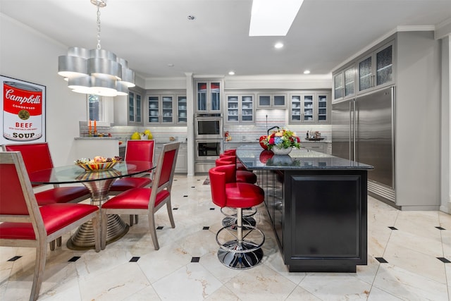 kitchen featuring ornamental molding, a center island, stainless steel appliances, and backsplash