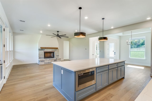 505 Aermotor Loop, Weatherford, TX 76085 - kitchen with gray cabinets, built in microwave, a kitchen island, recessed lighting, and a stone fireplace