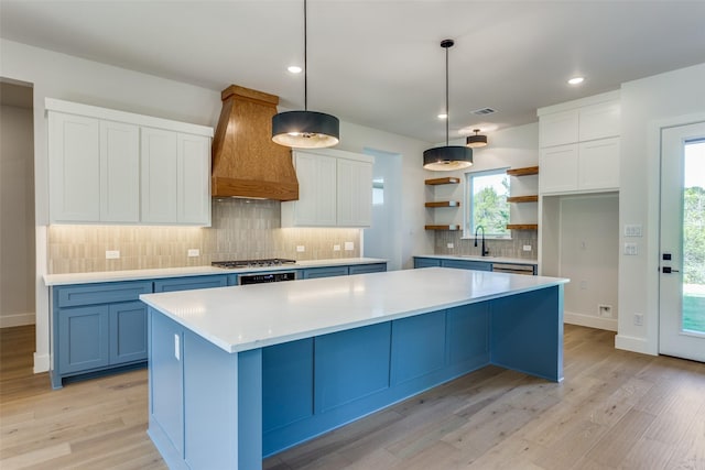 505 Aermotor Loop, Weatherford, TX 76085 - kitchen with custom exhaust hood, open shelves, light wood finished floors, a center island, and white cabinetry