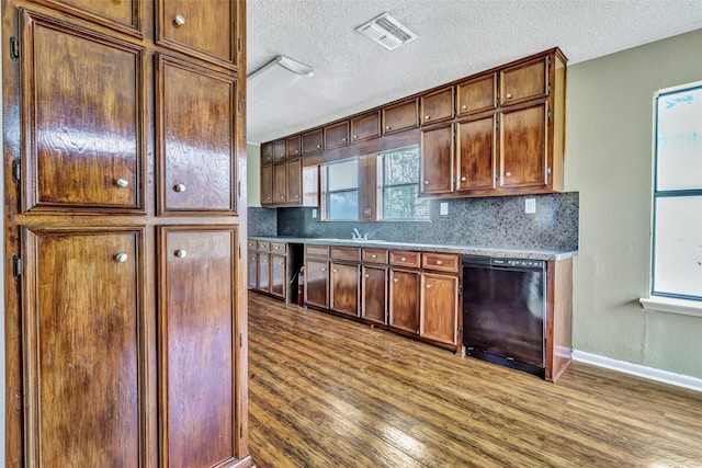 kitchen with dark wood-type flooring, dishwasher, and a wealth of natural light