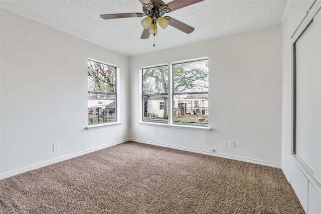 carpeted spare room with a textured ceiling and ceiling fan