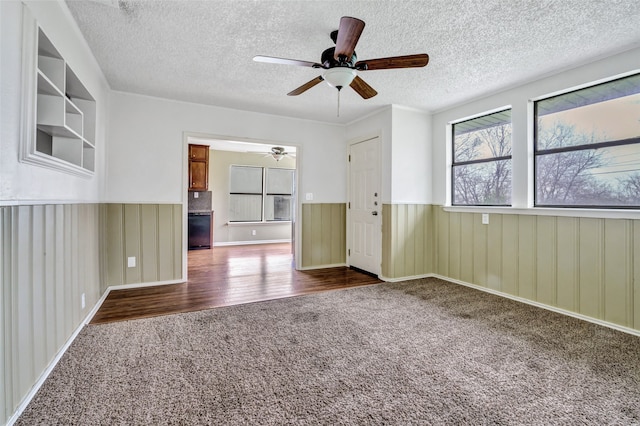 unfurnished room with dark hardwood / wood-style floors, a textured ceiling, and ceiling fan