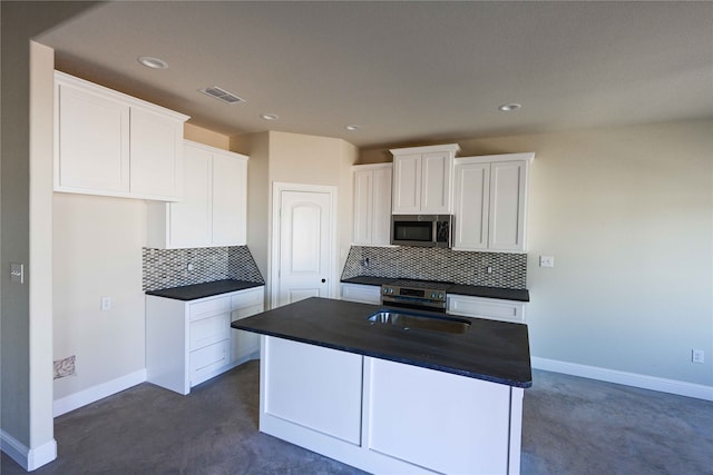 kitchen featuring decorative backsplash, a kitchen island, stainless steel appliances, sink, and white cabinetry