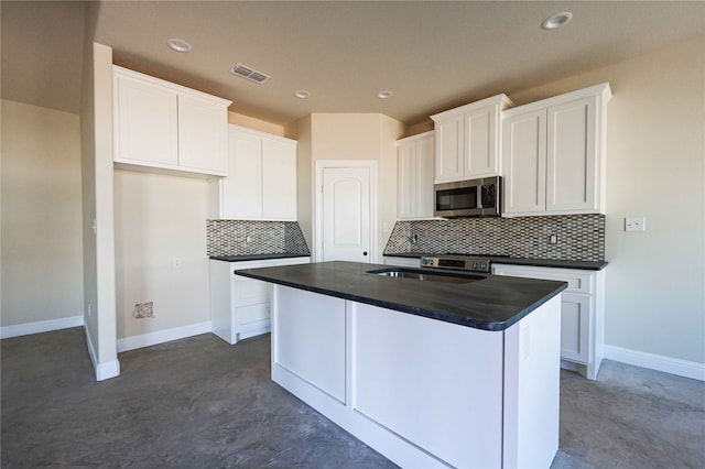 kitchen featuring sink, a center island, white cabinetry, and decorative backsplash