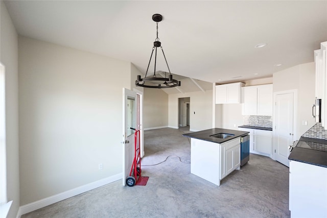 kitchen with a kitchen island, white cabinets, decorative backsplash, and pendant lighting