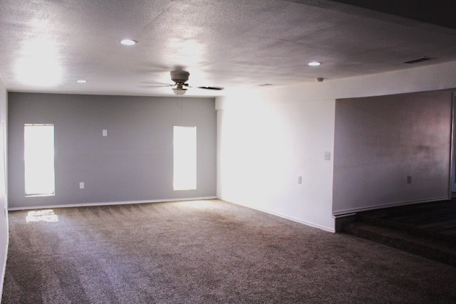 unfurnished room featuring a textured ceiling, carpet flooring, and ceiling fan