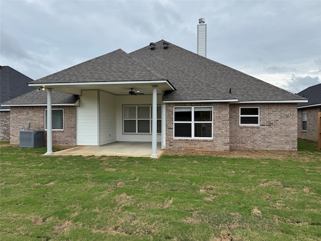 rear view of property featuring central air condition unit, a patio area, a lawn, and ceiling fan