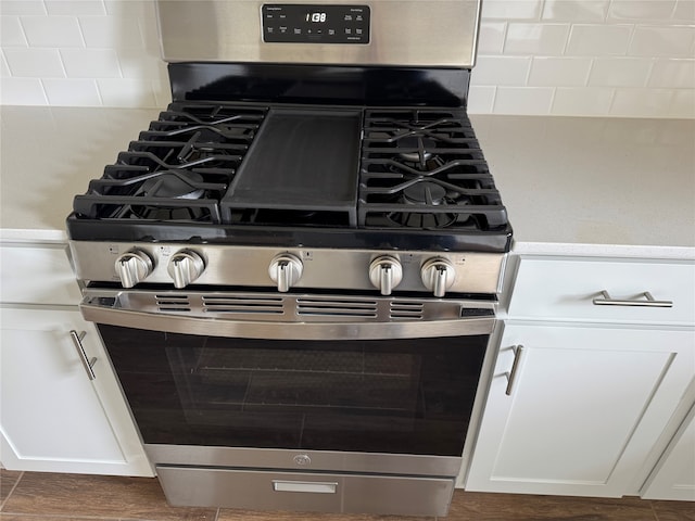 room details with white cabinets and stainless steel gas stove