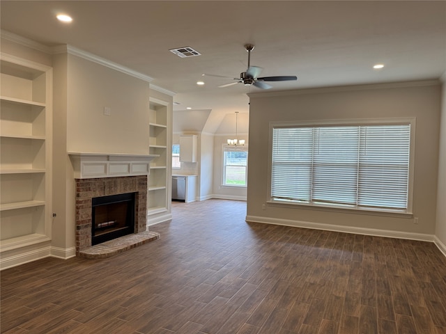 unfurnished living room featuring built in features, dark hardwood / wood-style floors, ceiling fan with notable chandelier, and a brick fireplace