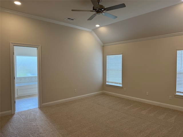 carpeted spare room with crown molding, vaulted ceiling, and ceiling fan