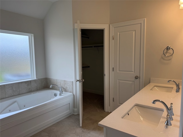 bathroom with lofted ceiling, tile patterned floors, a bathtub, and a wealth of natural light