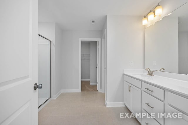 bathroom featuring tile patterned flooring, vanity, and walk in shower