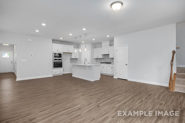 unfurnished living room featuring sink and dark hardwood / wood-style floors