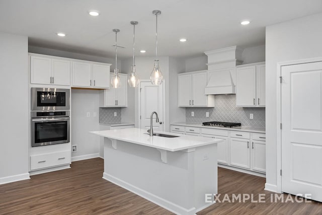 kitchen featuring white cabinetry, a center island with sink, and decorative light fixtures