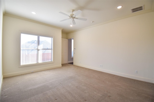 spare room featuring ceiling fan, light colored carpet, and ornamental molding