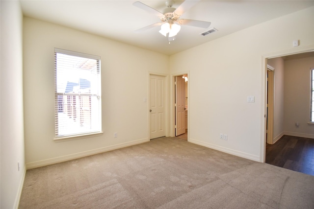 empty room featuring light colored carpet and ceiling fan