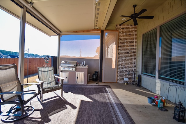 view of patio featuring grilling area, an outdoor kitchen, a mountain view, and ceiling fan