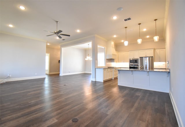 kitchen with white cabinetry, hanging light fixtures, dark hardwood / wood-style flooring, stainless steel appliances, and ceiling fan with notable chandelier