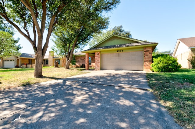 ranch-style home featuring a front lawn and a garage