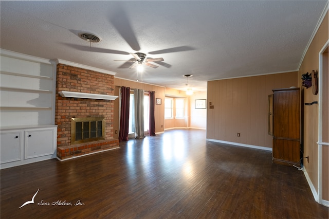 unfurnished living room with dark hardwood / wood-style floors, crown molding, a brick fireplace, a textured ceiling, and ceiling fan