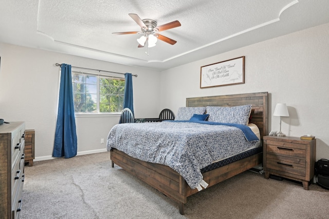 carpeted bedroom featuring ceiling fan and a textured ceiling