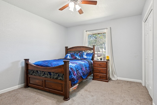 carpeted bedroom featuring a closet, ceiling fan, and a textured ceiling