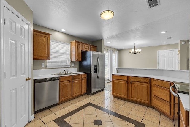 kitchen with pendant lighting, stainless steel appliances, an inviting chandelier, and light tile patterned floors