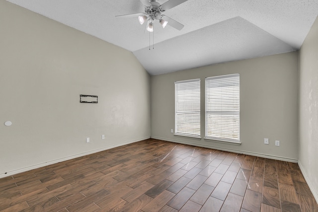 empty room with lofted ceiling, dark wood-type flooring, a textured ceiling, and ceiling fan