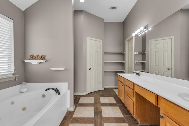 bathroom featuring vanity, tile patterned floors, and a washtub