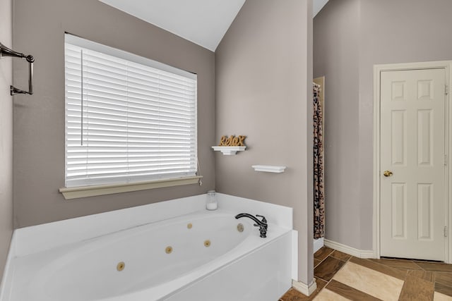 bathroom with lofted ceiling and a bathing tub