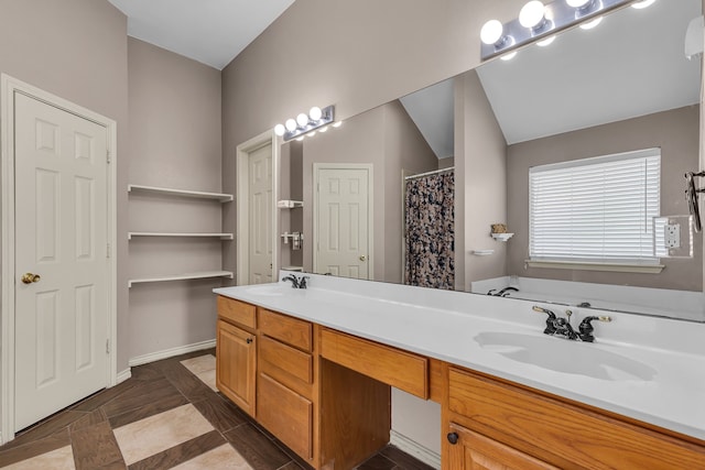 bathroom with vanity, lofted ceiling, tile patterned floors, and a washtub