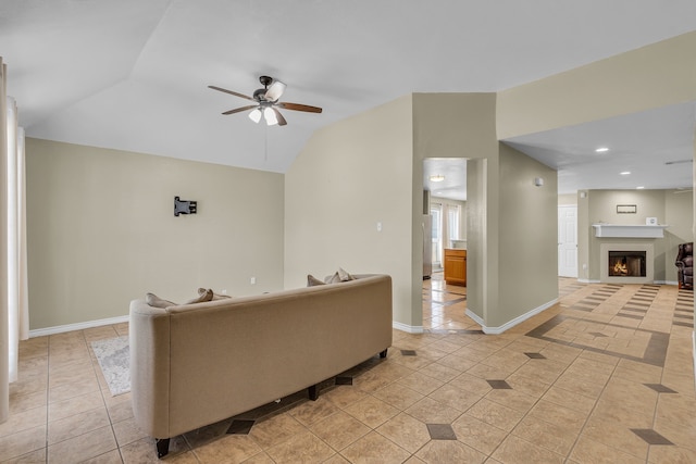 living room featuring ceiling fan, vaulted ceiling, and light tile patterned floors