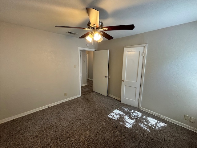 unfurnished bedroom featuring ceiling fan and dark carpet