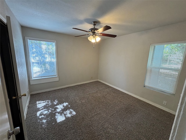 carpeted spare room featuring a textured ceiling and ceiling fan