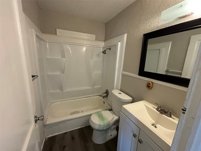 full bathroom featuring hardwood / wood-style flooring, toilet, shower / bath combination, vanity, and a textured ceiling