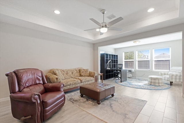 living room featuring ceiling fan, a raised ceiling, light hardwood / wood-style flooring, and crown molding