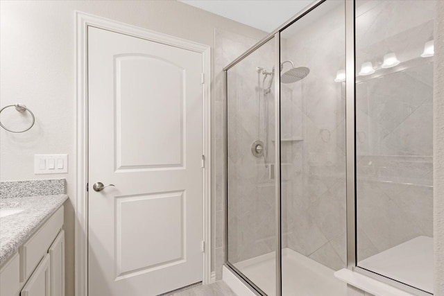 bathroom with vanity and a shower with door