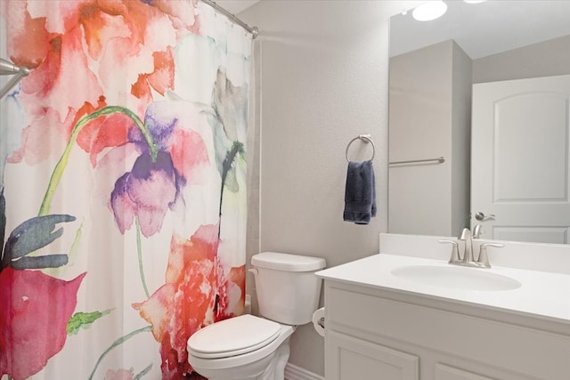 bathroom featuring walk in shower, vanity, and toilet