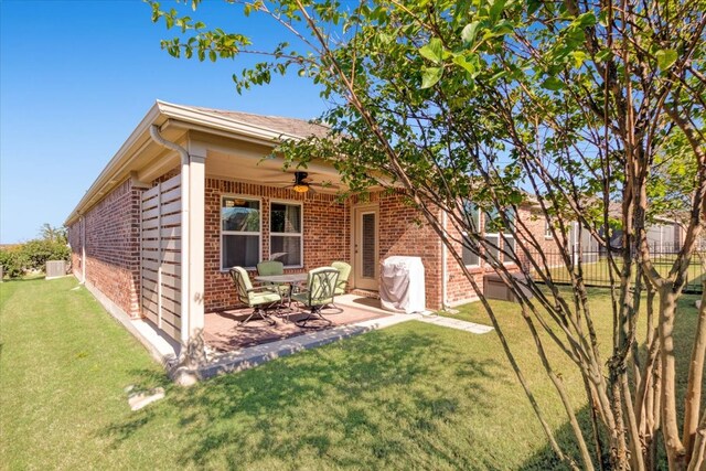 rear view of property featuring a patio area, a lawn, and ceiling fan