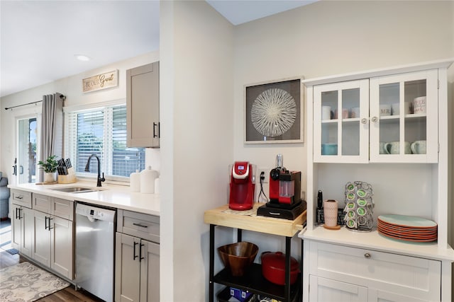 kitchen featuring dishwasher, sink, gray cabinets, and dark hardwood / wood-style floors