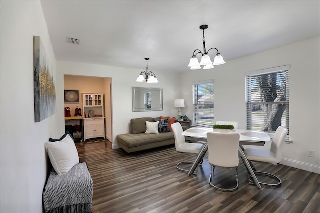 dining space featuring a notable chandelier and dark hardwood / wood-style floors