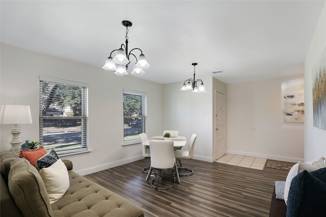 dining area with dark hardwood / wood-style flooring and a notable chandelier